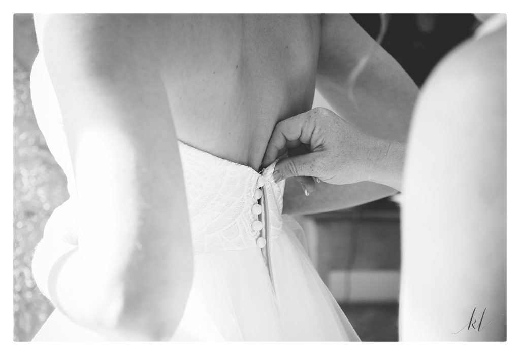 Black and white close up photo of the back of the brides wedding dress as she is getting ready for her Whimsical Summer Wedding at the BVI. 
