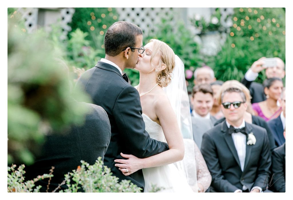 First Kiss of a bride and groom during their wedding ceremony at the Bedford Village Inn by K. Lenox Photography. 