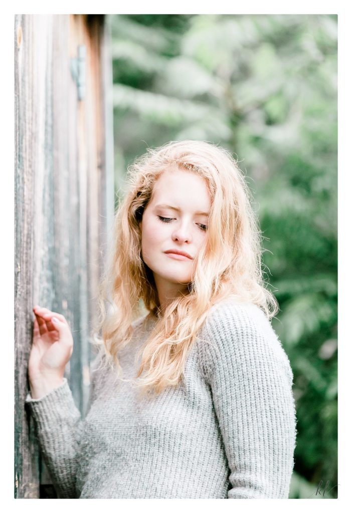 Light and airy senior portrait of a blonde girl wearing a grey sweater. Taken by K. Lenox Photography in Keene. 
