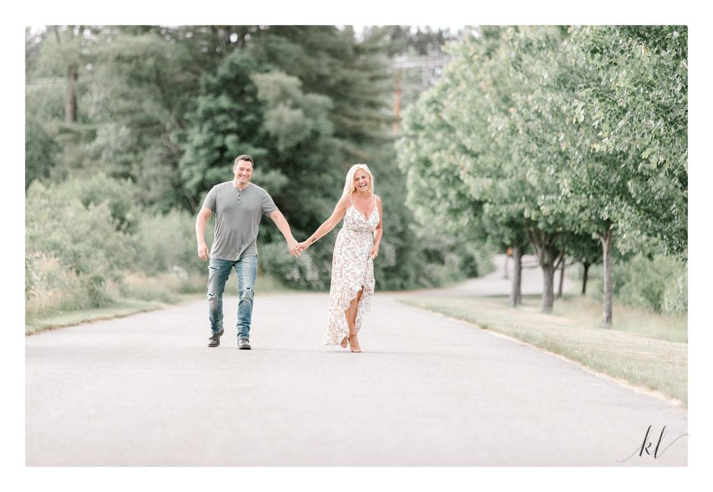 Fun and Laid back couples session. Man and woman walking hand in hand on a path. Light and airy photography
