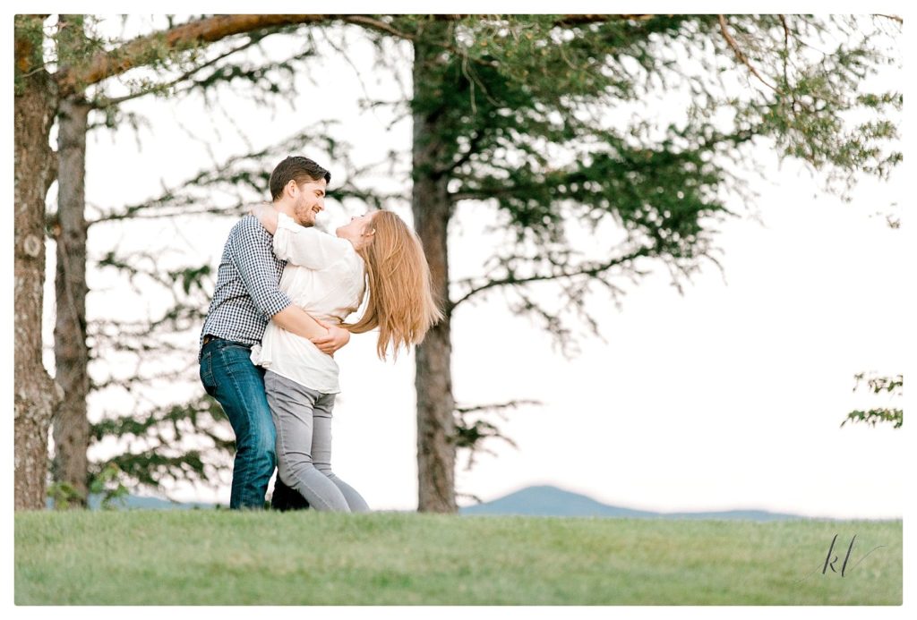 Man and woman playfully hugging during their engagement session. 