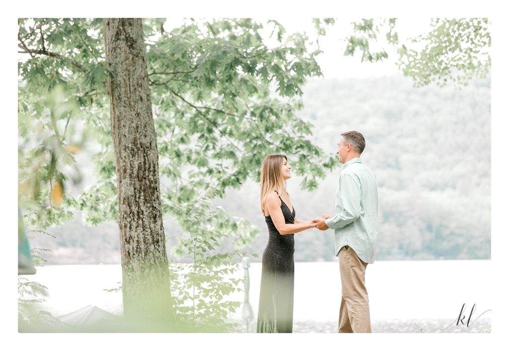 Light and Airy candid photo of a man and woman during their rustic engagement photo session on Swanzey Lake. 