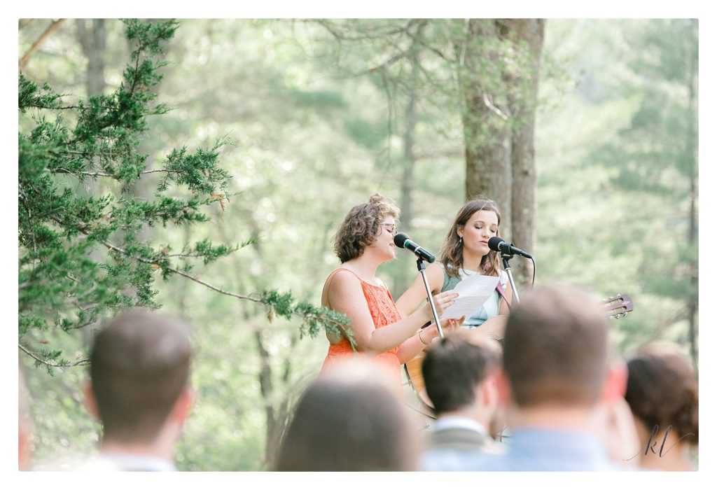 Two girls sing and play the guitar for a wedding ceremony that is casually elegant. 