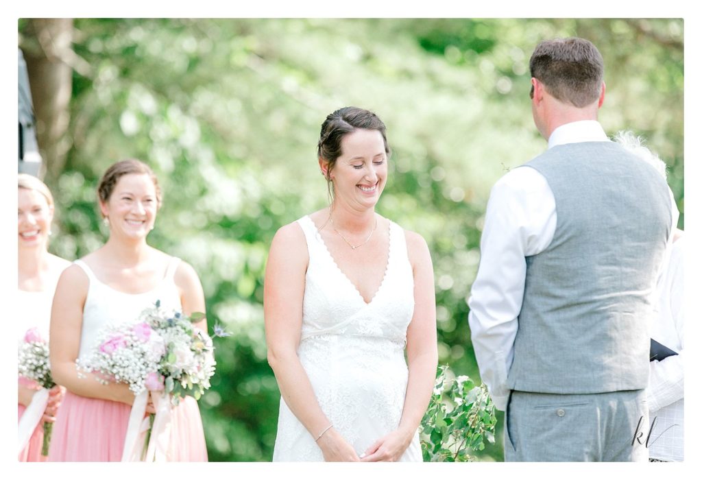 Bride looks down and smiles during their Casually Elegant Backyard wedding. 
