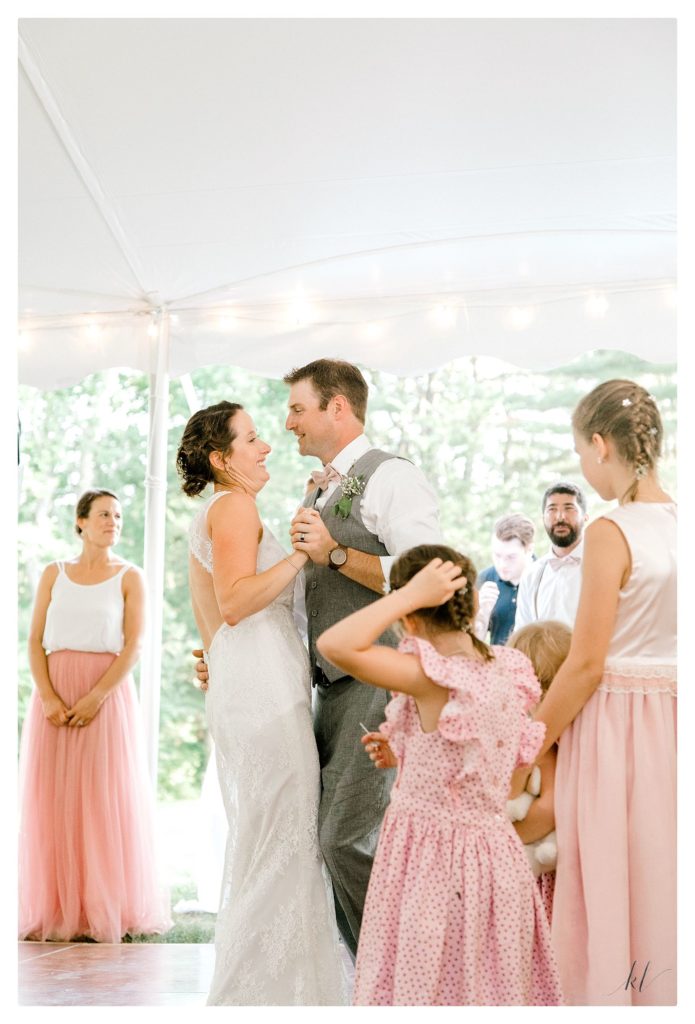 Bride and Groom share their first dance as husband and wife under a white reception tent. 