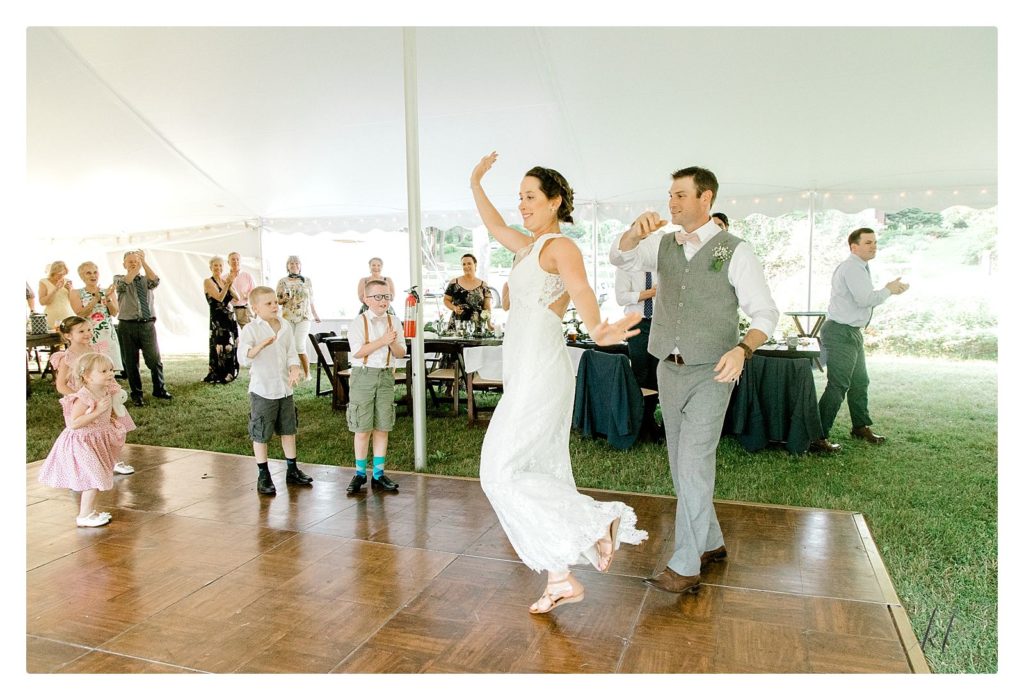Bride and Groom dance into the tent during their casual yet elegant backyard tent wedding. 