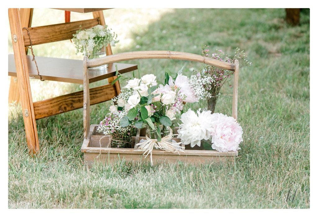 Rustic basket holding various floral arrangements for a casually elegant backyard wedding in NH.