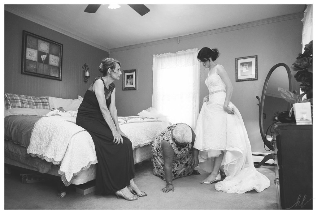 Black and White photo of Bride getting into her wedding dress for her Keene Country Club Summer Wedding. 