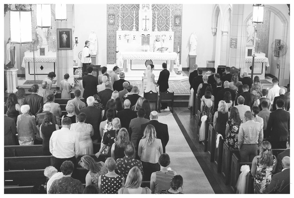 Black and White photo of a Catholic Wedding Ceremony taken from a Balcony. 