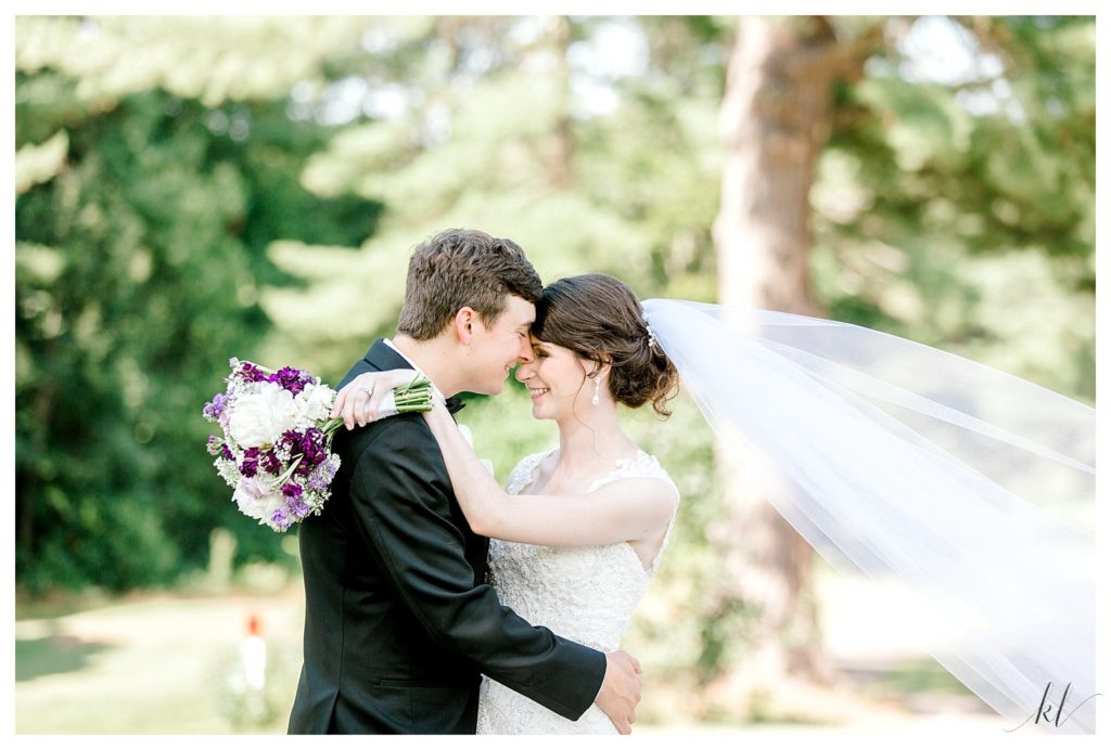 Bright and Airy photo of a bride and groom holding each other at their summer keene Country club wedding. 