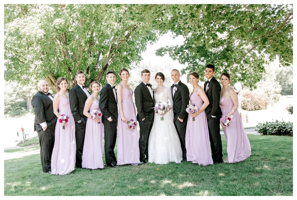 Wedding party wearing purple dresses and the men wearing tuxes at the Keene Country Club. 