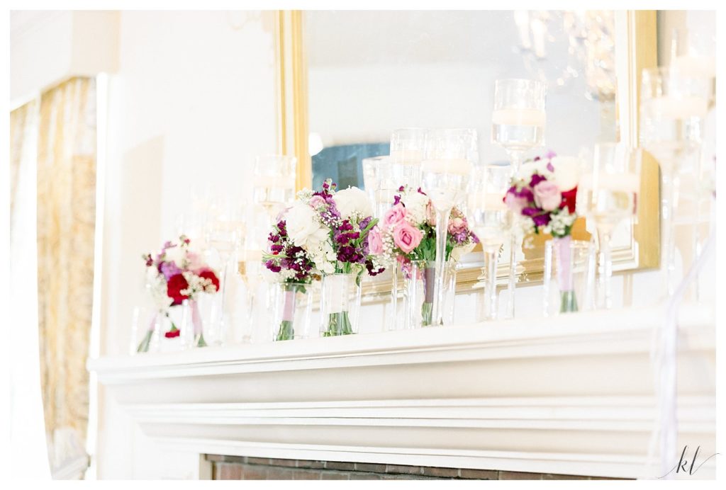 Bright and Airy photo of the Keene Country Club's Ballroom Fireplace mantle with floral bouquets. 