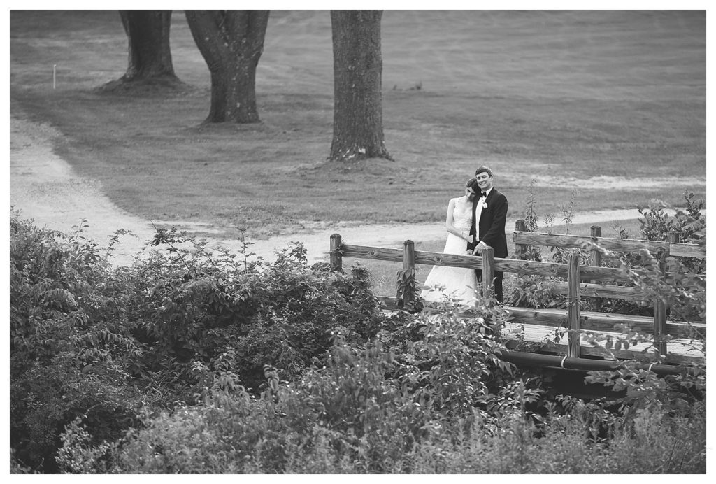 Black and White photo of a bride and groom on the bridge at the Keene Country Club on their wedding day. Taken by K. Lenox Photography. 