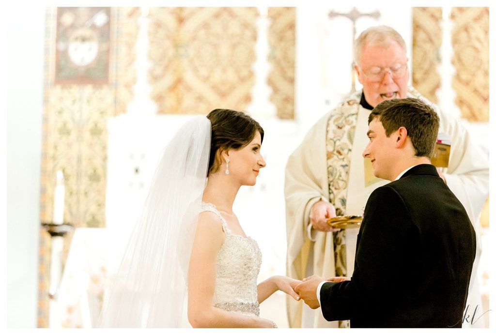 Bride and Groom exchange rings during a Catholic summer wedding ceremony. 