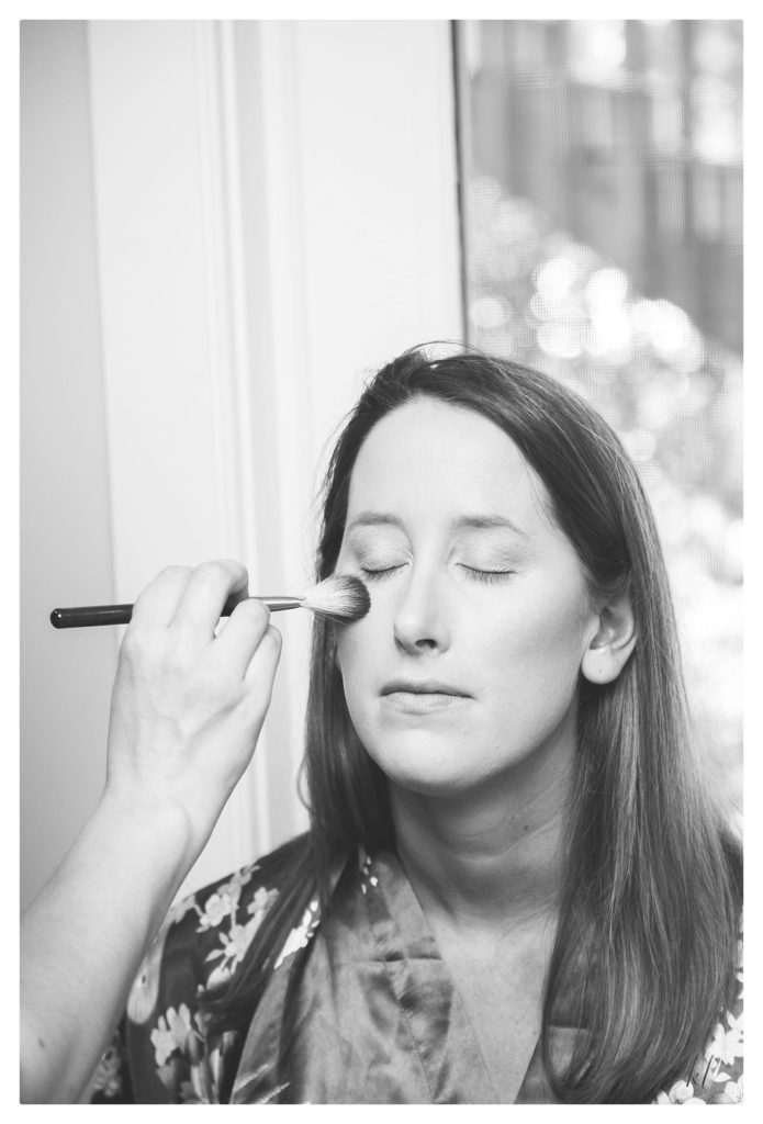 Bride gets her makeup applied to her beautiful fresh skin. 