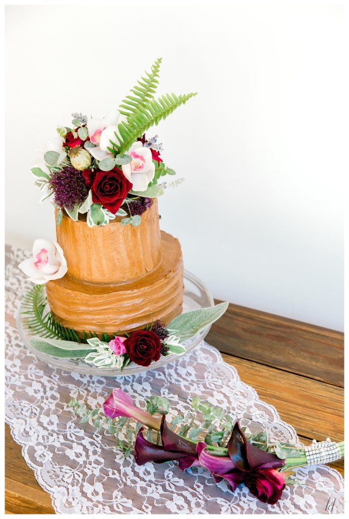 simple Two tiered chocolate frosted wedding cake topped with a floral arrangement- and Calla Lillies 