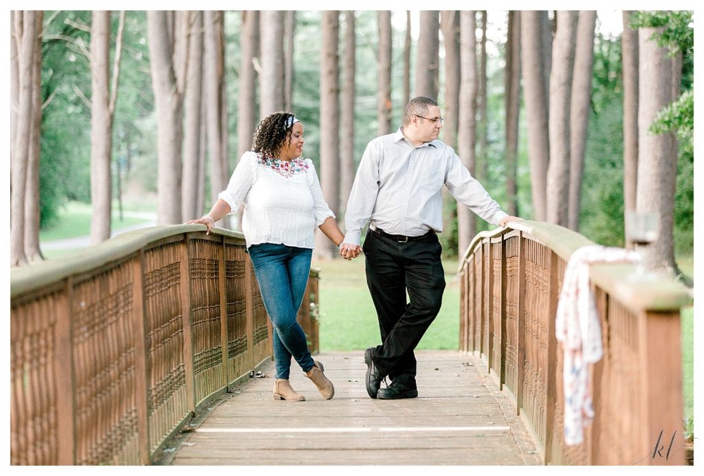 Man and Woman hold hands while on the bridge during their Alpine Grove Engagement Session | Hollis NH - 