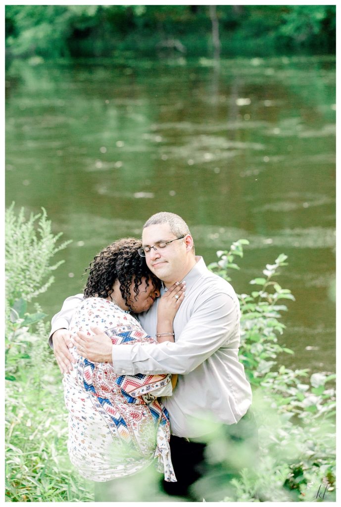 Man and Woman hugging with a river in the background during their Alpine Grove Engagement Session | Hollis NH - 