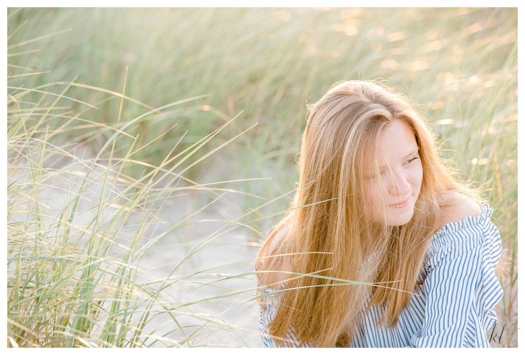 Candid and natural portrait of a girl looking over her shoulder while sitting on the sand dunes on Drakes Island Wells 