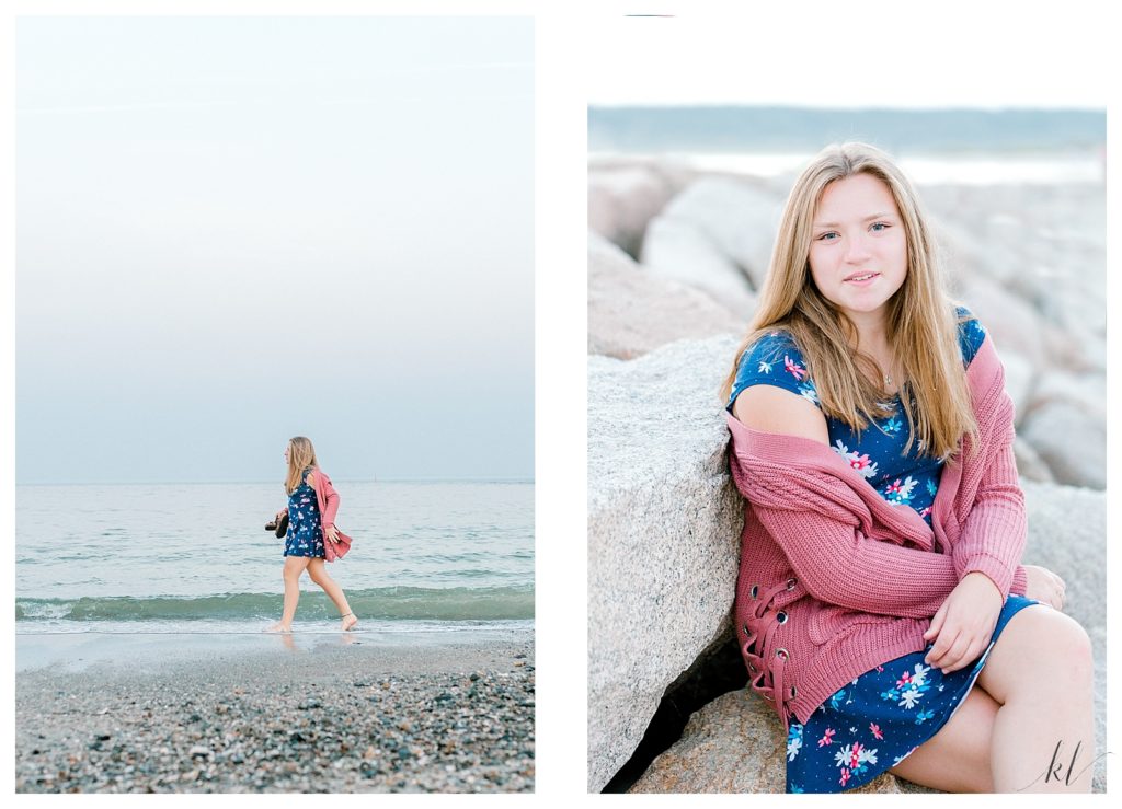 Drakes Island senior portraits taken of a girl walking on a beach wearing a pink sweater and a blue dress. 