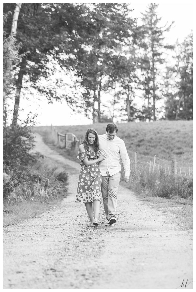 Candid black and white photo of a man and woman walking on a dirt road at Mayfair Farm in Harrisville NH