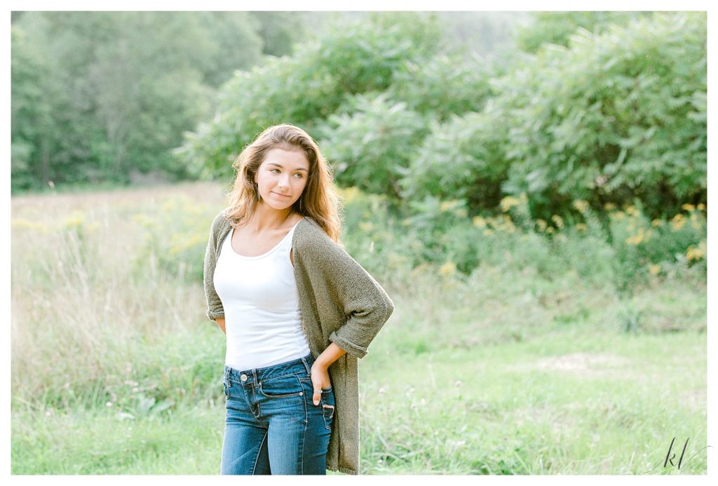 Light and Airy Senior portrait taken just outside of Keene NH by K. Lenox Photography. Girl wearing blue-jeans, white tank and a green sweater. 