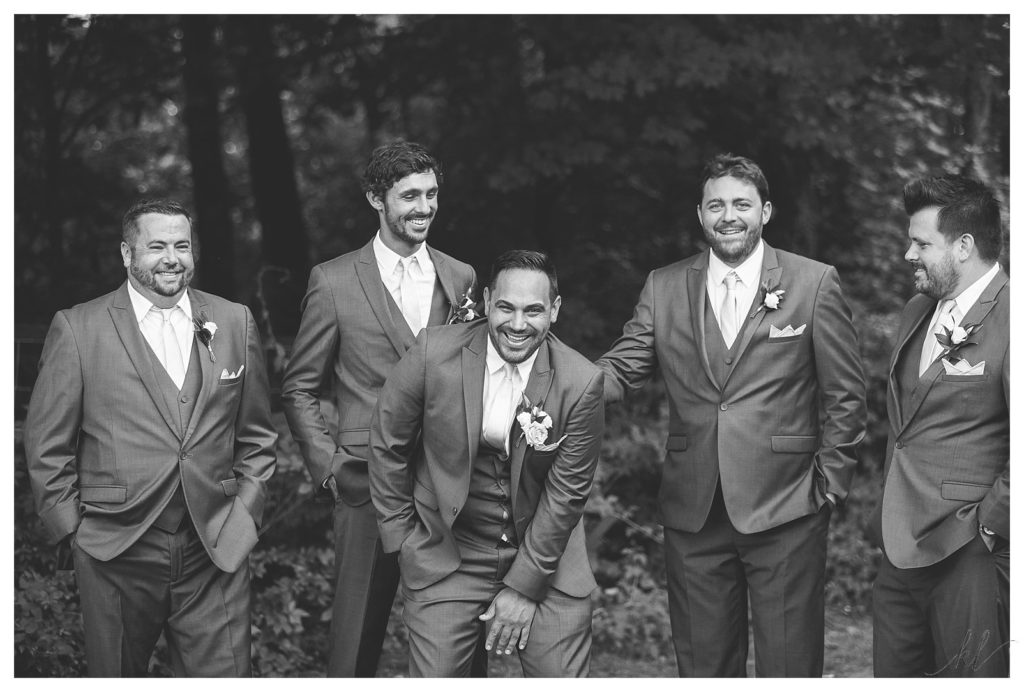 Candid, Black and White photo of a groom and his groomsmen hanging out. 