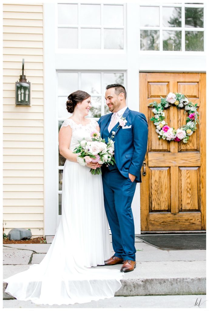 Formal portrait of a bride and groom in front of the door at the Bedford Village Inn. 