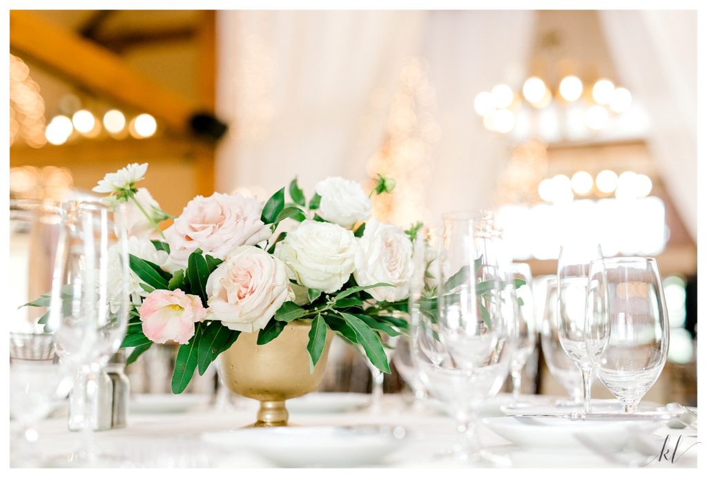 Light and Airy floral wedding table centerpiece with white and light pink flowers in a gold container. 