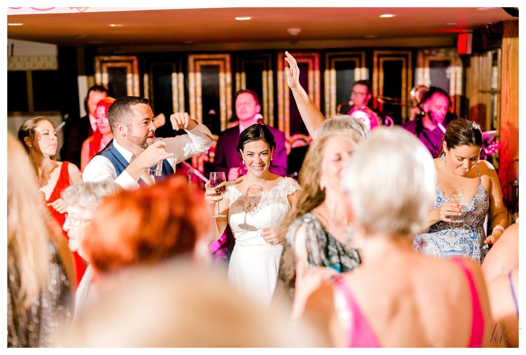 Candid photo of a Bride holding her wine on the dance floor at her Wedding at the Bedford Village Inn. 