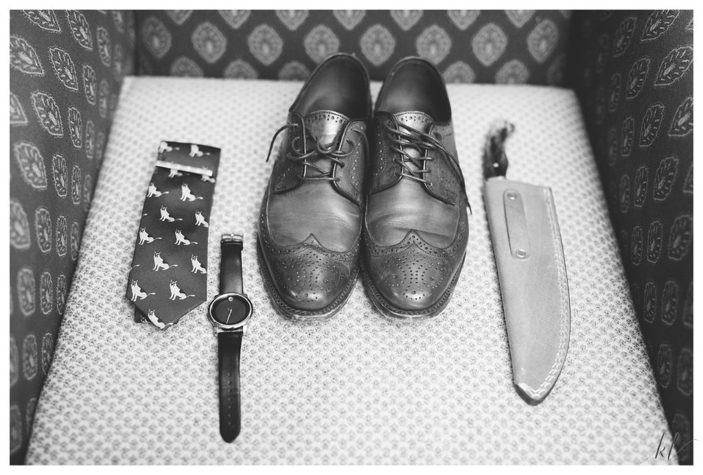 Black and White detail photo showing all the grooms details. Custom tie, shoes, watch and carving knife. 