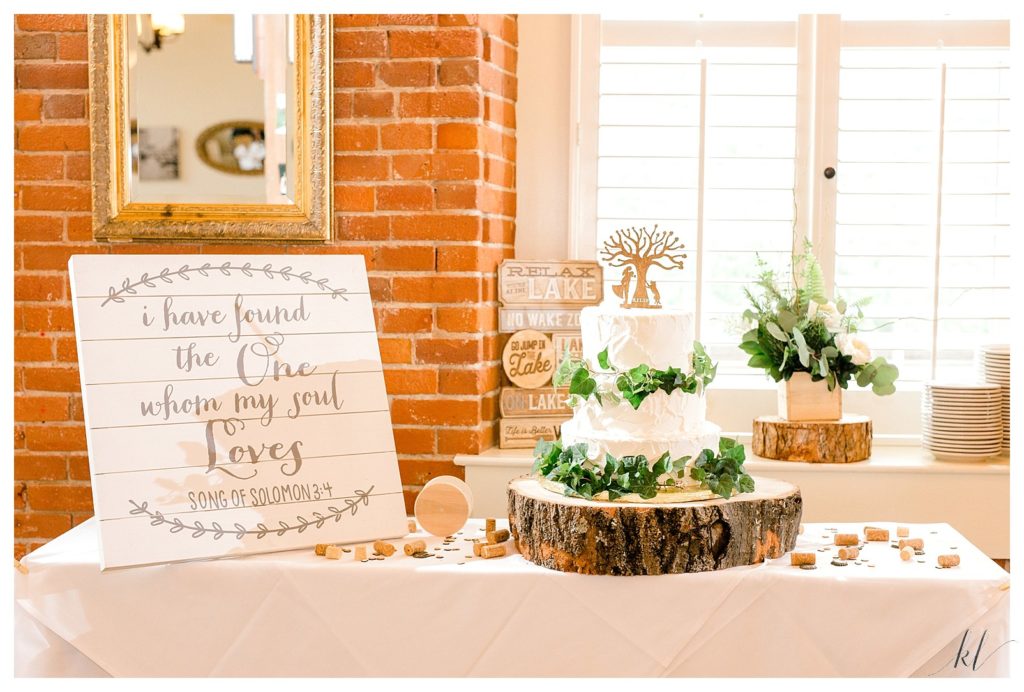Cake table with rustic wooden tree cake stand and a wooden sign with Song of Solomon 3:4 