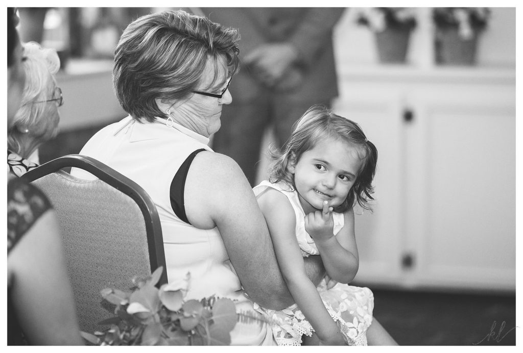 Black and White Candid photo of a young girl during a wedding ceremony. 