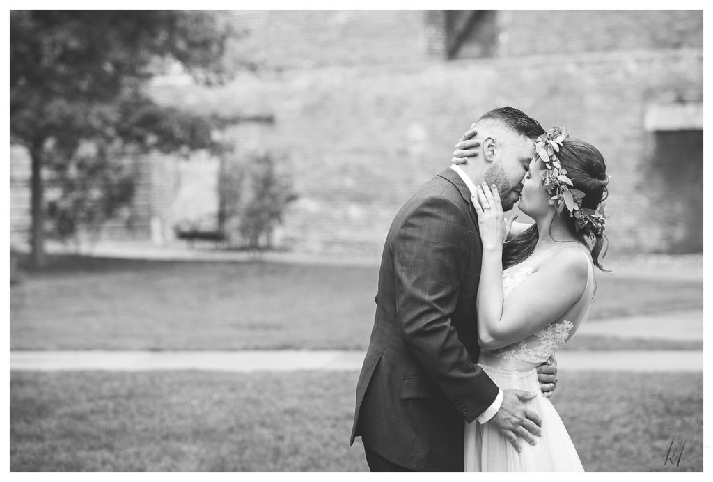 Black and white photo of a groom kissing his bride in the courtyard Wedding at The Common Man Claremont