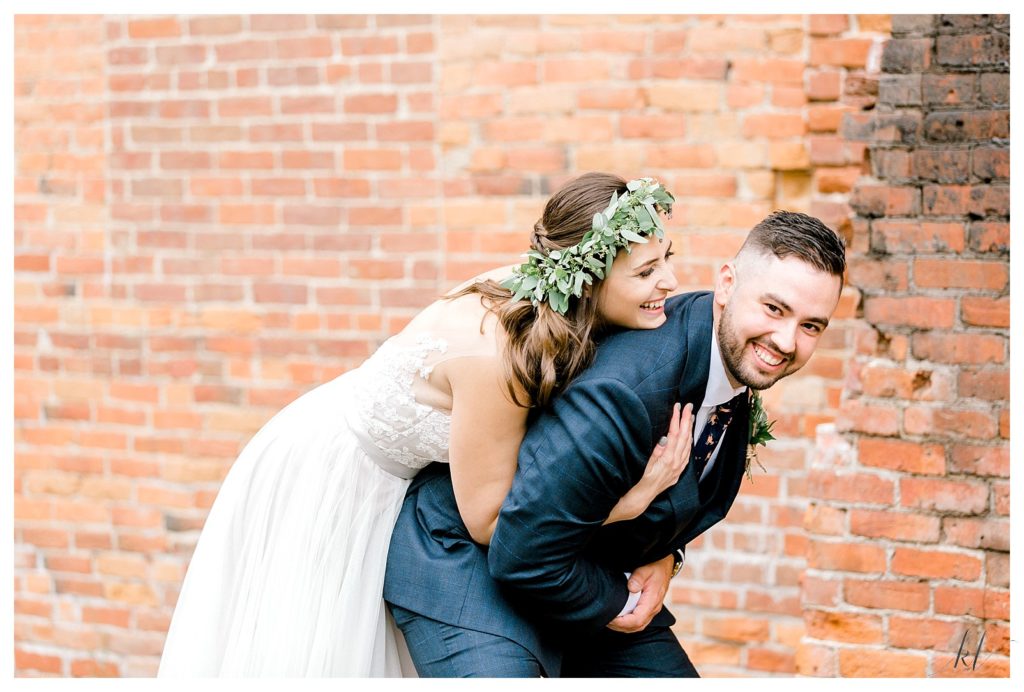 Fun and laid back candid picture of a bride and groom in front of the brick wall at Wedding at The Common Man Claremont