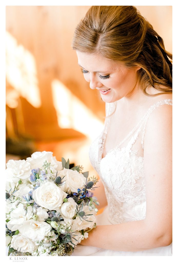 Light and airy Bridal portrait of a bride looking down at her white hyndrea bouquet.