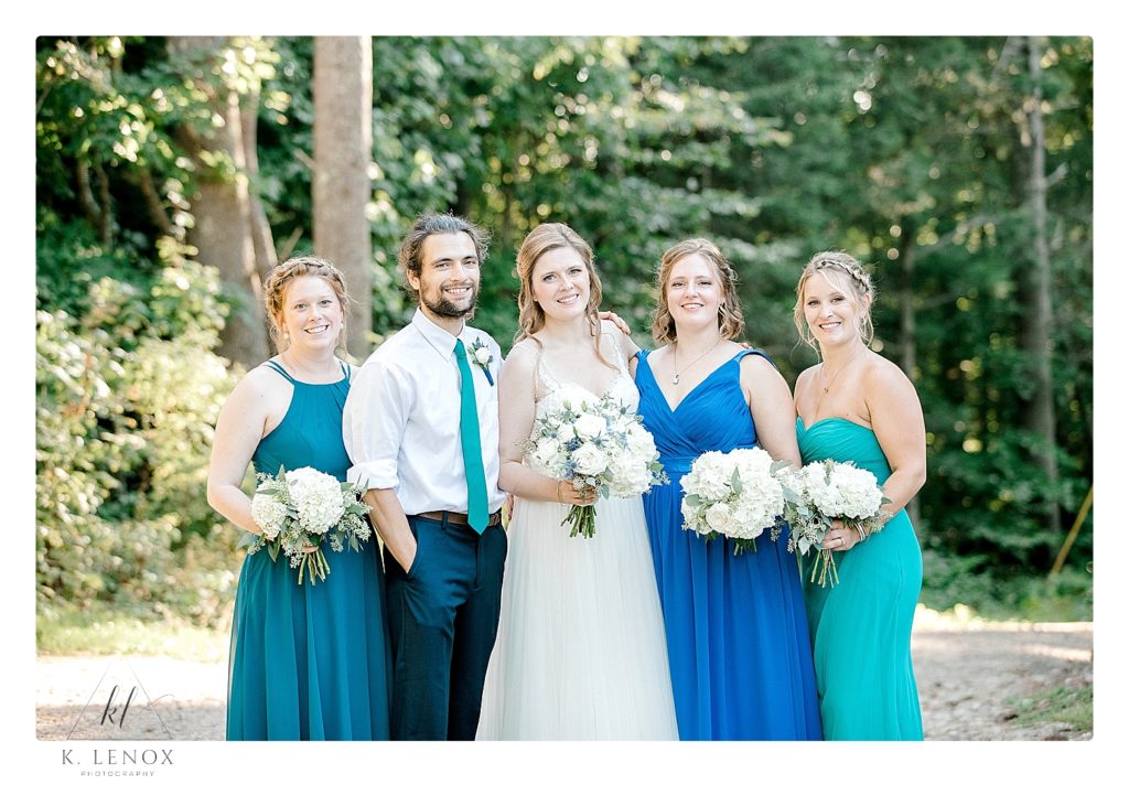 Bride and her attendants- wearing various shades of Blue bridesmaids dresses. 