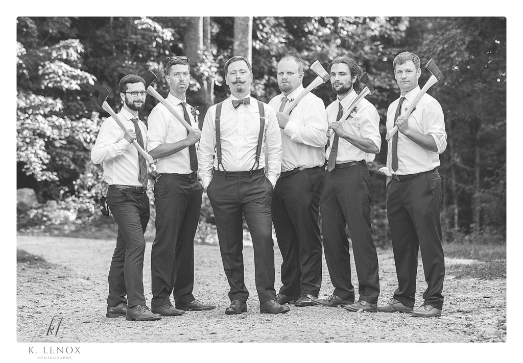 Black and white photo of a groom and his groomsmen holding their gifts Custom Axe's. 