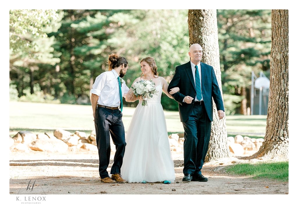 Bride is walked down the aisle by her father and her brother