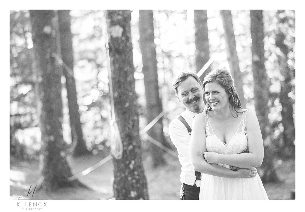 Black and white photo of a bride and groom hugging
