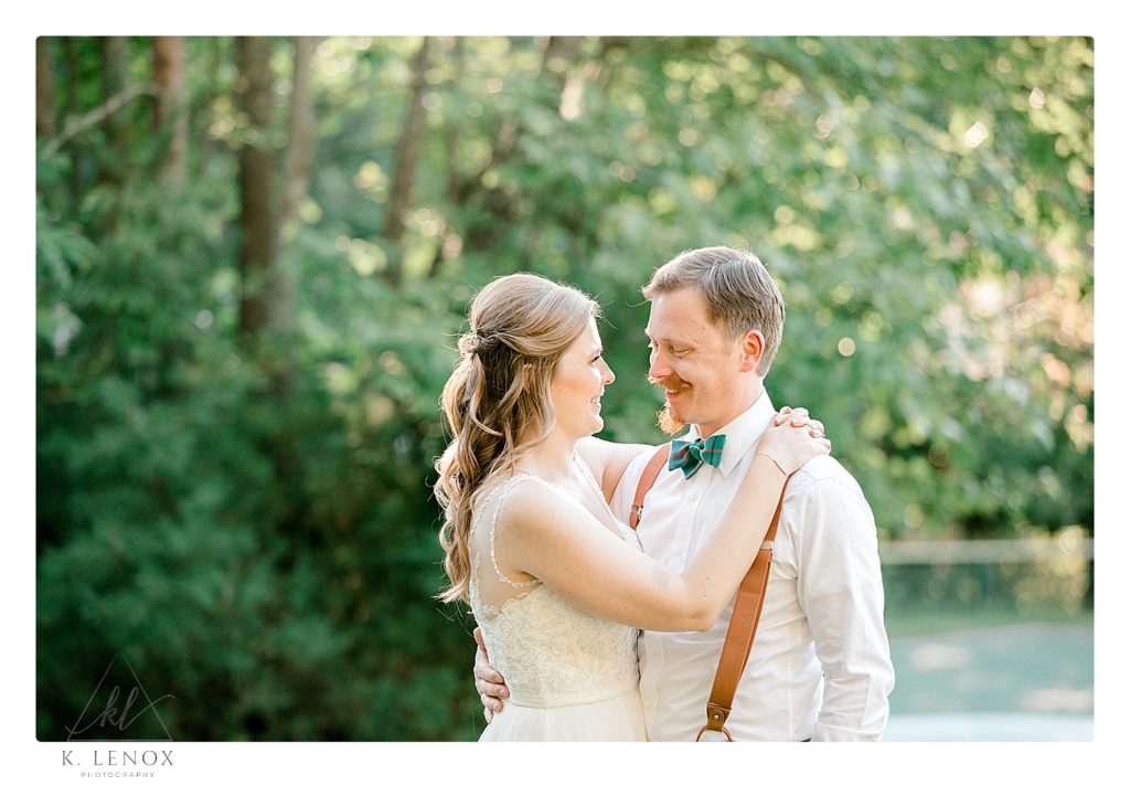 Bride wraps her arms around her groom for a light and airy wedding photo. 