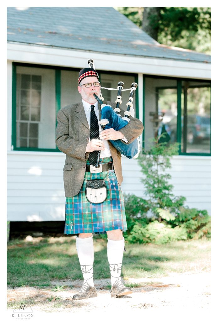 Bagpipe player wearing blue and green plaid kilt plays the bagpipes after a wedding ceremony