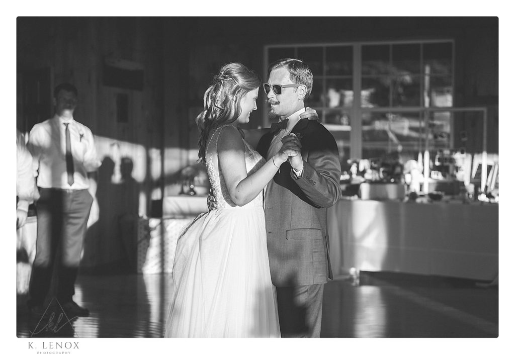 Black and white photo of a bride and groom's first dance at the Centennial Lodge at the William lawrence camp. 