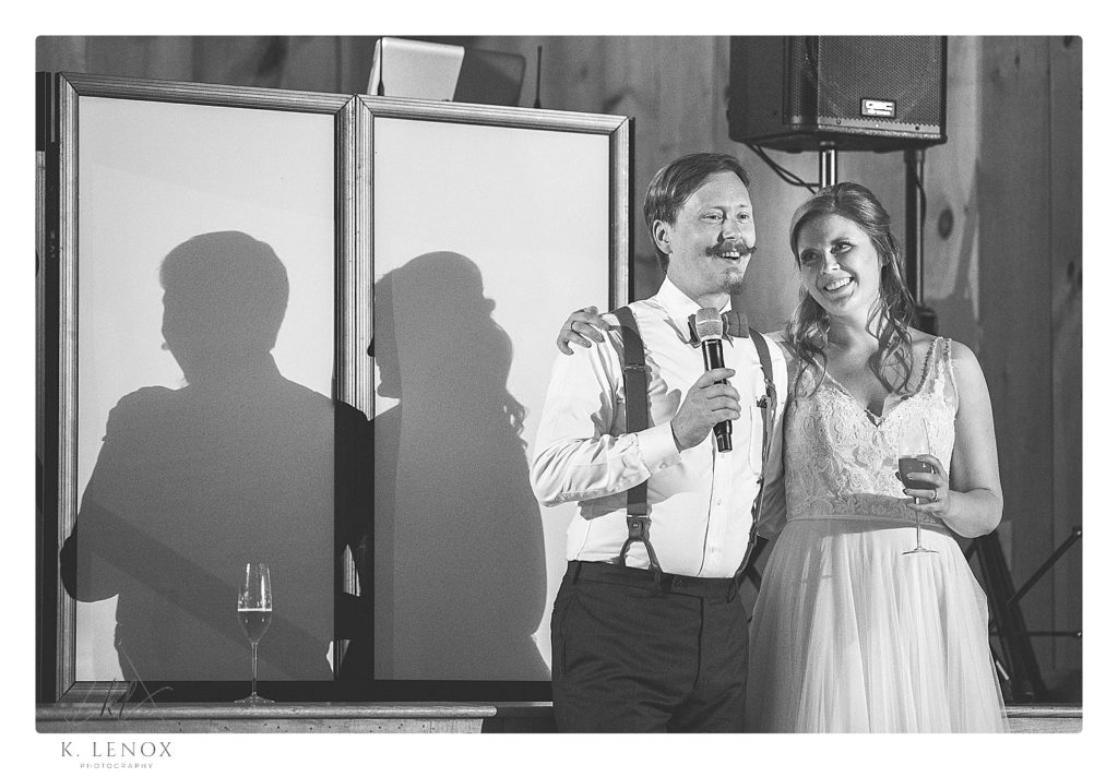 Black and white photo of a bride and groom giving a toast at their wedding reception. 