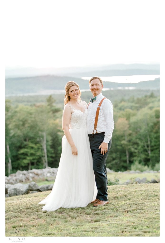 Bride and Groom pose for a formal portrait in front of the beautiful view overlooking the NH mountains. 