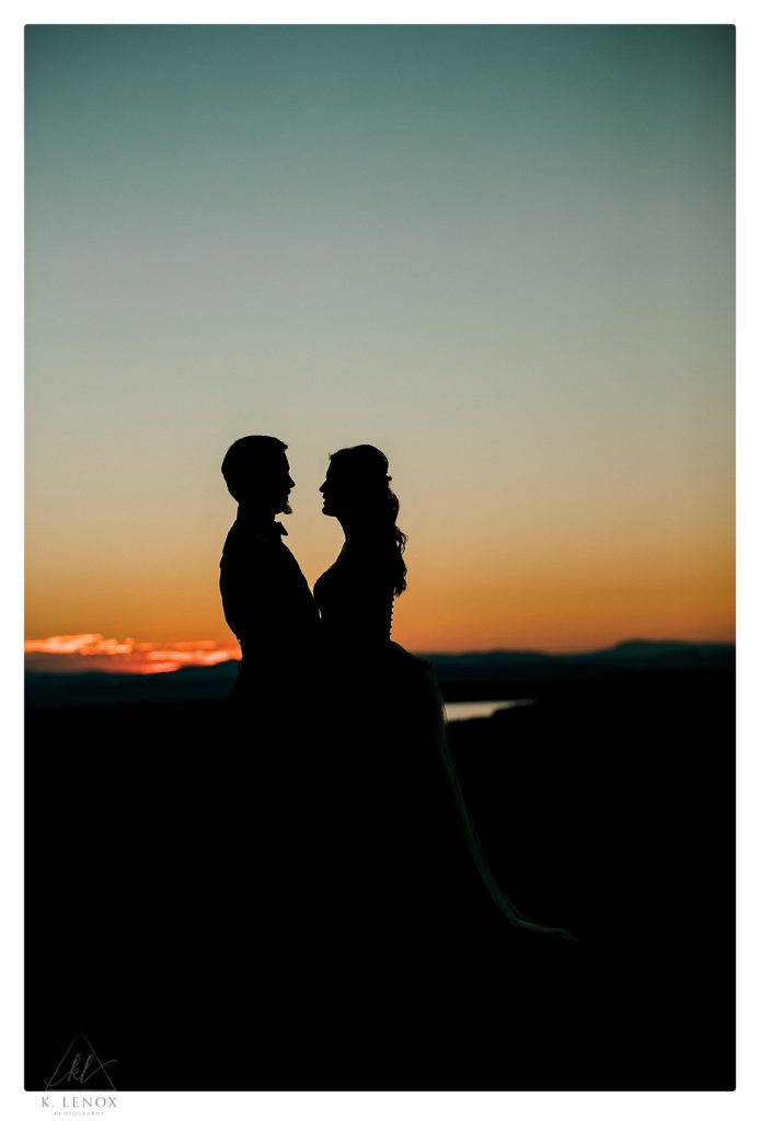 Silhouette photo of a bride and groom at sunset on their wedding day. 
