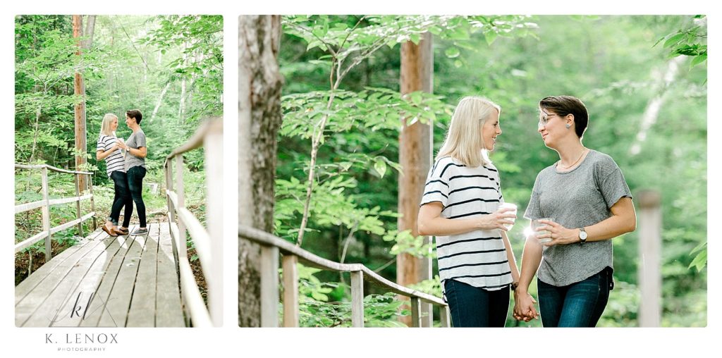 Engaged couple wearing simple tee-shirts and dark jeans holding hands on a foot bridge in the woods of Mt. Sunapee. 