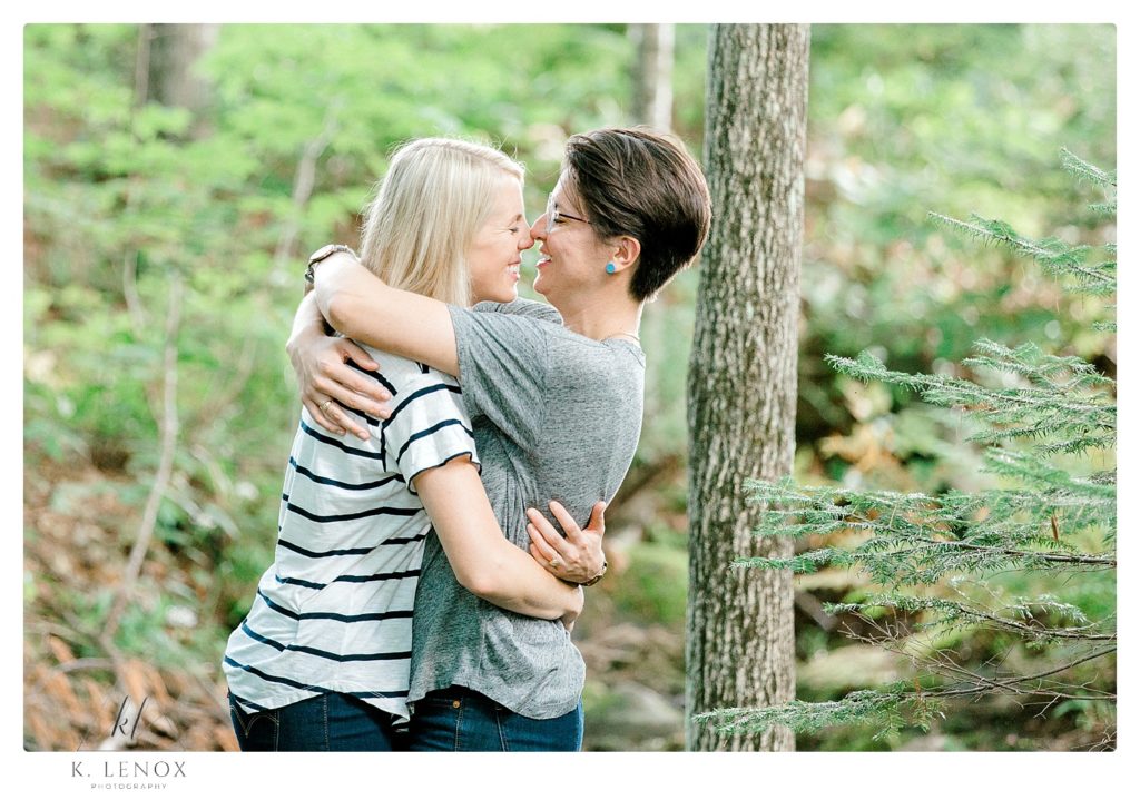Engaged female couple hug for a natural and candid photo during their engagement session. 