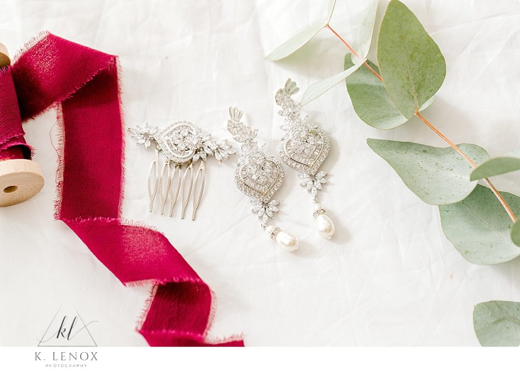 Detail photo showing burgundy ribbon with White gold and diamond earrings and a hair piece for the bride. 