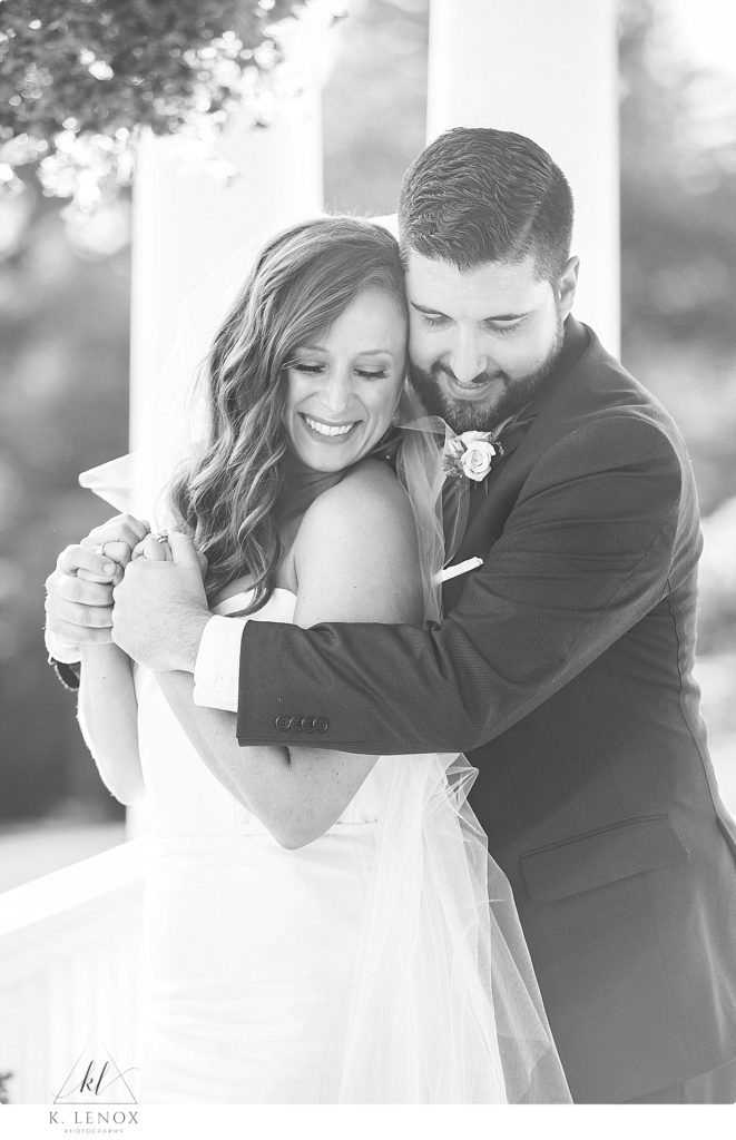 Black and White photo of a bride and groom hugging on their wedding day. 